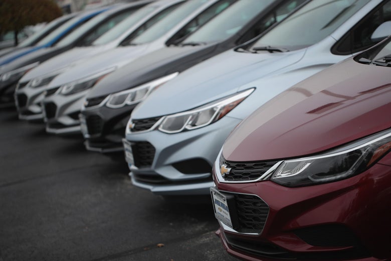 A line of several Chevy Cruzes of different colors seen from the side